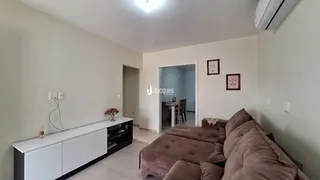 Sala de estar com sofá e móveis brancos.