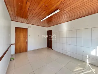 Ambiente interno com piso de cerâmica e forro de madeira.
