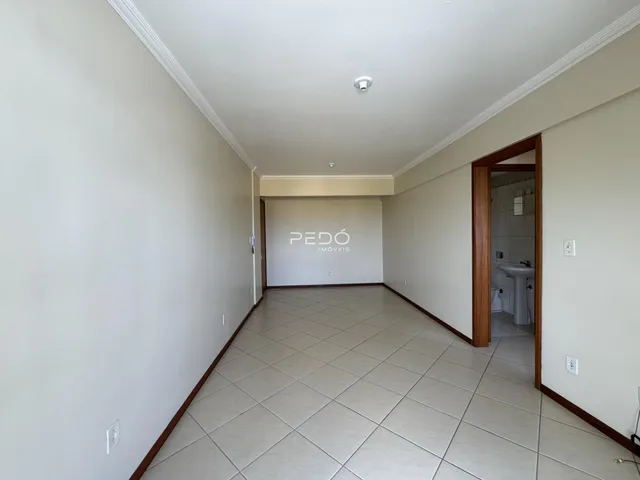 Corredor interno com piso de cerâmica e paredes brancas.