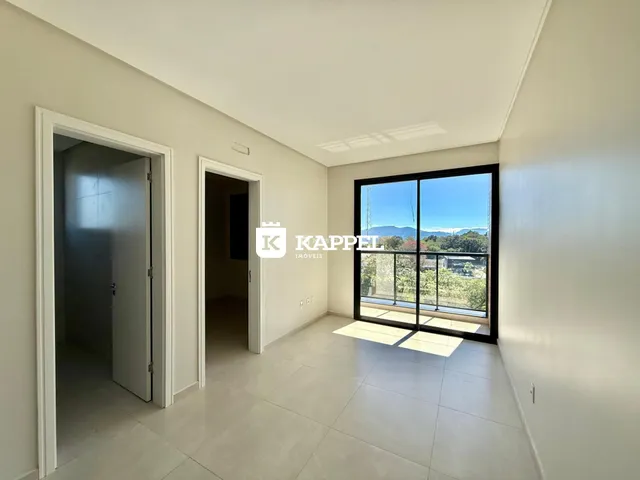 Foto de um corredor interno com uma grande janela que oferece uma vista panorâmica da paisagem.