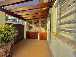 Vista de uma área externa coberta com estrutura de madeira e revestimento de parede em Lajeado.