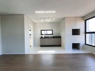 Sala de estar moderna com piso de madeira e cozinha integrada.