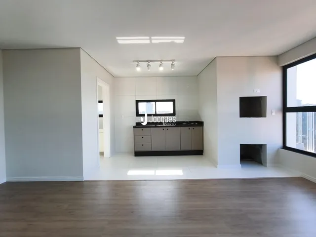 Sala de estar moderna com piso de madeira e cozinha integrada.