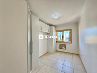 Ambiente interno com piso de cerâmica e armários brancos em um imóvel em Lajeado.
