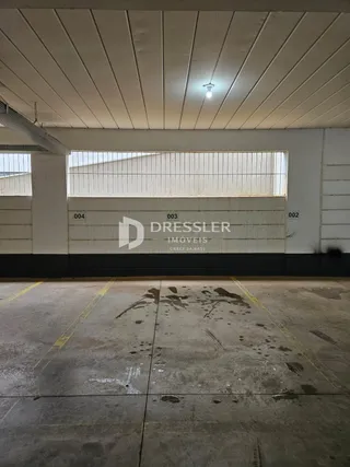Foto de um espaço interno com piso de concreto e teto branco.