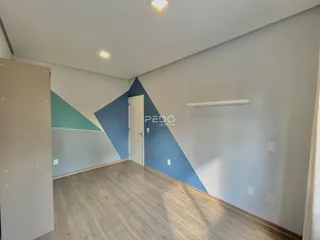 Ambiente interno de uma sala com piso de madeira e paredes em tons de azul.