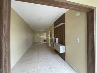 Corredor interno de uma residência com piso de cerâmica.