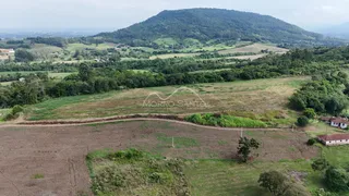 Vista panorâmica de paisagem rural com colinas verdes e campos abertos.