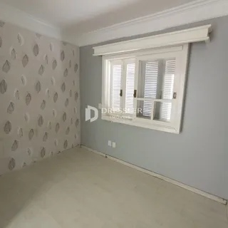 Quarto com parede decorada e janela com persianas no interior de uma residência.