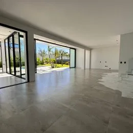 Ambiente amplo com piso claro e portas de vidro que dão acesso ao exterior.