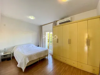 Quarto com cama e armário em madeira clara.