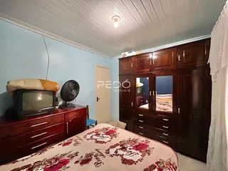 A foto mostra um quarto com cama e armário de madeira.