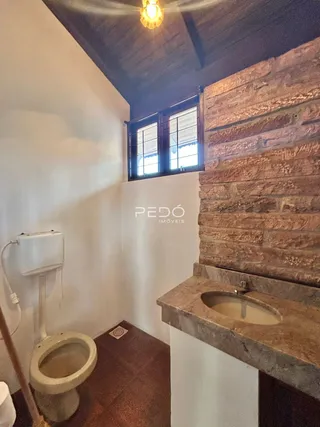 Foto de um ambiente interno com vaso sanitário e bancada de pedra.
