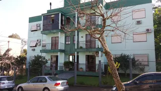 Fachada de um prédio residencial em Lajeado, Brasil, com varandas e vegetação.