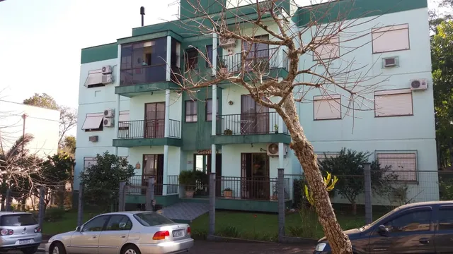 Fachada de um prédio residencial em Lajeado, Brasil, com varandas e vegetação.