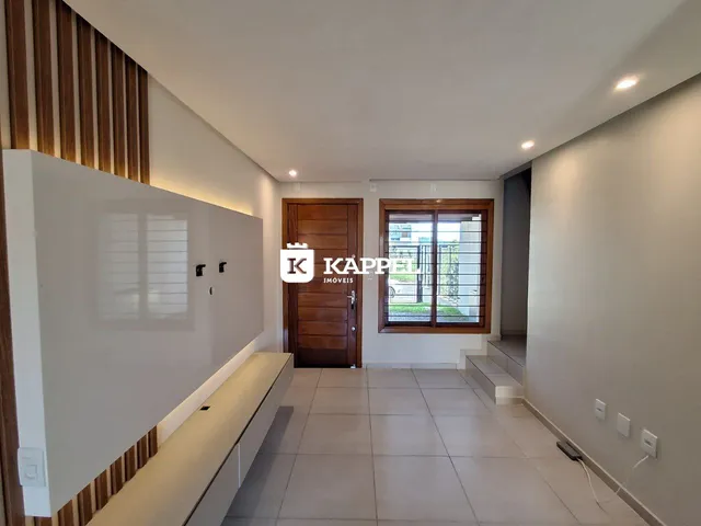 Hall de entrada com piso de cerâmica e porta de madeira em um imóvel.