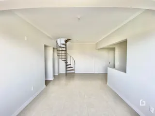 Vista de um corredor interno com paredes brancas e piso claro.