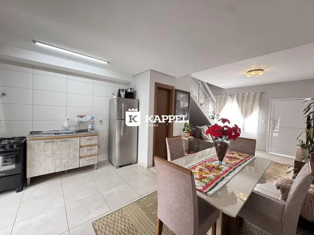 Foto de uma sala de estar e cozinha moderna com armários brancos e piso de cerâmica.