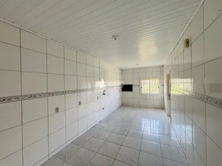 Hall de corredor interno com piso de cerâmica e paredes brancas.