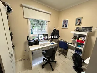 Escritório com mesa de trabalho e janela em ambiente interno.