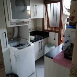 Foto de uma cozinha com armários brancos e bancada.