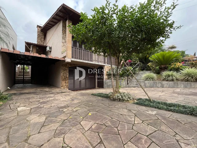 Vista externa de uma residência em Lajeado, Brasil, com área pavimentada e jardim.