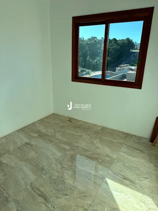 Vista interna de uma sala com piso de porcelanato claro e janela.