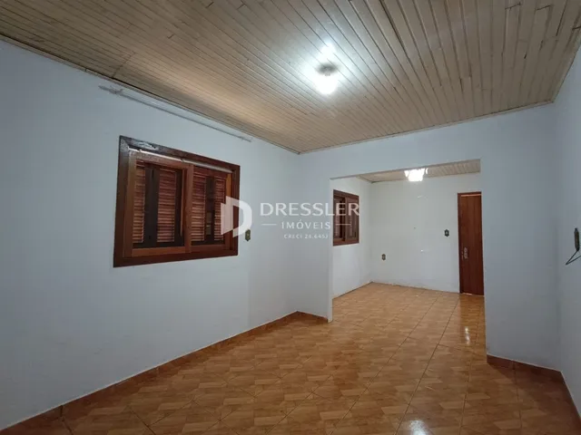 Interior de uma sala com piso de cerâmica e teto de madeira.