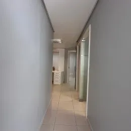 Hall de entrada com paredes brancas e piso de cerâmica.