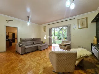 Sala de estar com piso de madeira e móveis.