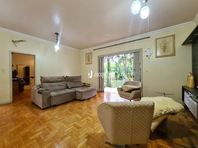 Sala de estar com piso de madeira e móveis.