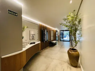 Hall de entrada com revestimento de madeira e iluminação moderna.