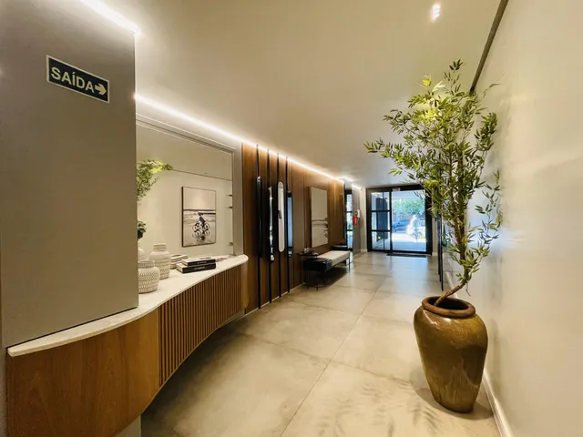 Hall de entrada com revestimento de madeira e iluminação moderna.