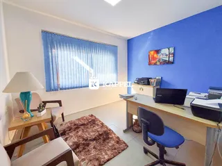 Uma sala de escritório com uma mesa de trabalho e uma janela grande.