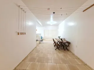 Hall de corredor com piso de cerâmica claro.