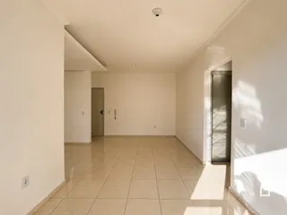 Vista de um corredor interno com piso de cerâmica claro.