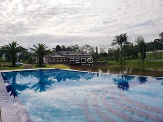 Vista externa de uma propriedade com piscina e paisagem ao redor.
