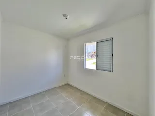 Ambiente interno de uma sala com paredes brancas e piso de cerâmica.