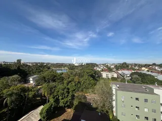 Vista aérea de uma área residencial com vegetação e corpo d'água.