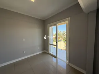 Esta é uma sala de estar com piso de cerâmica e porta de vidro que dá para o exterior.