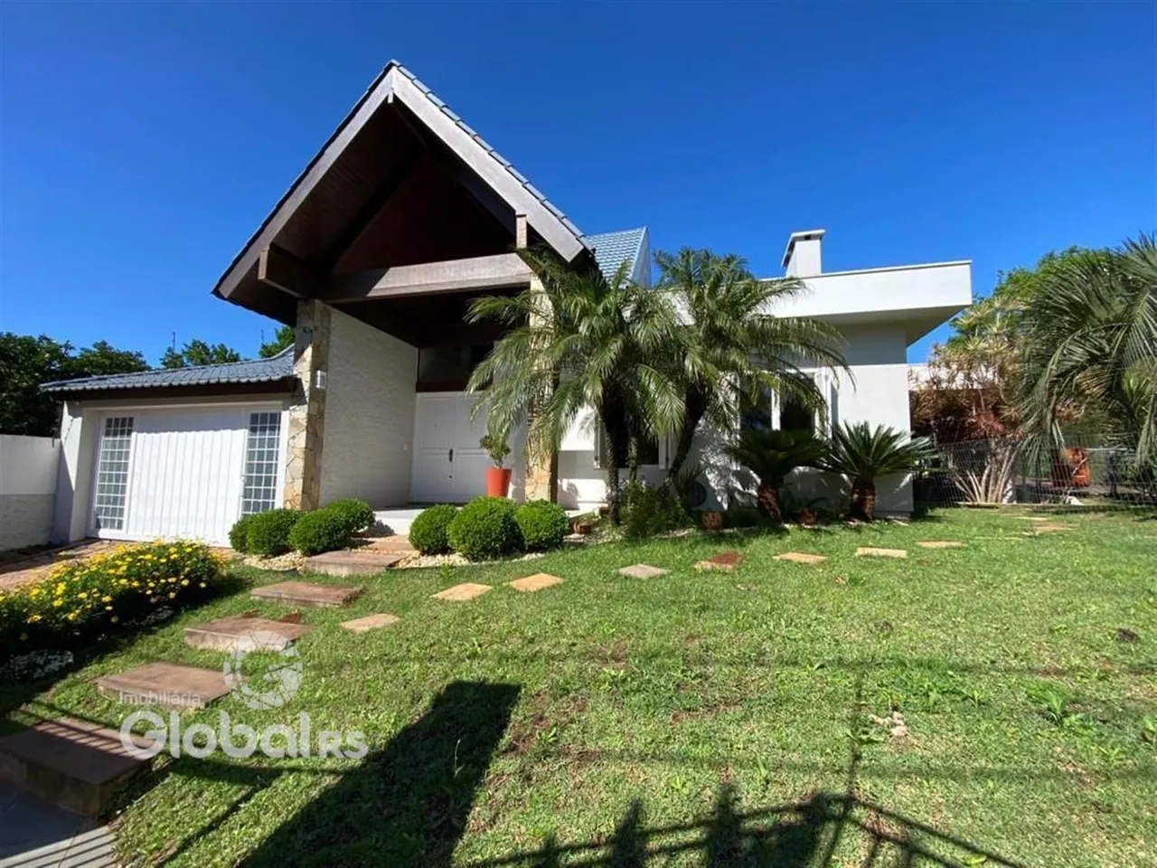 Fachada de uma residência com jardim verde em Lajeado, Brasil.