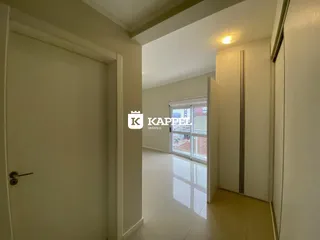 Hall de entrada com piso claro e paredes brancas em um imóvel.