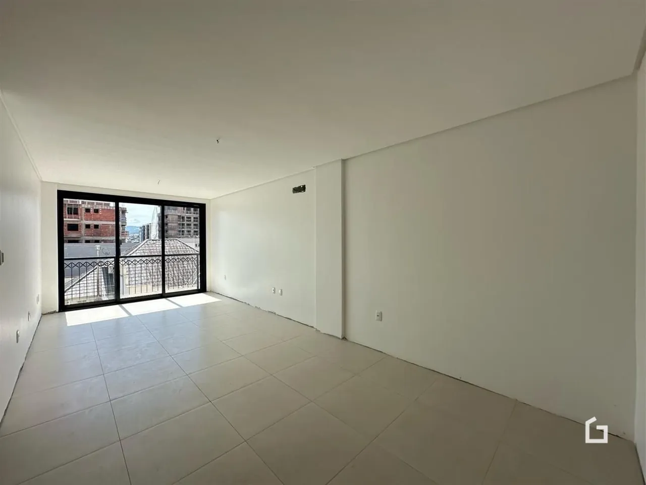 Ambiente interno de uma sala com piso de cerâmica e porta de vidro.
