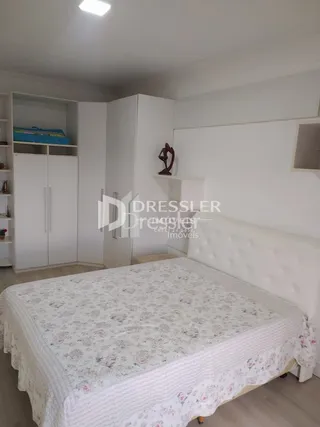 Quarto com cama de casal e paredes brancas em um imóvel.