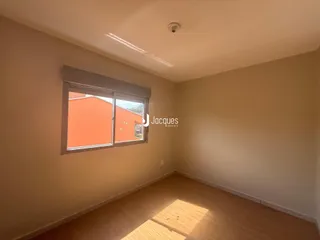 Ambiente interno de uma sala com piso de madeira e janela.
