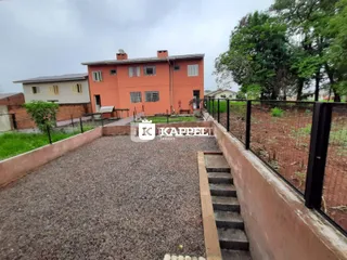 Vista externa de uma casa de dois andares em Lajeado com pátio de cascalho.