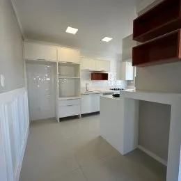 Interior de um cômodo com paredes brancas e armários em um imóvel em Lajeado.
