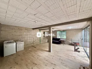 Foto de uma sala ampla com piso de madeira clara e máquina de lavar roupa.