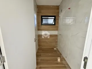 Hall de passagem com piso e paredes revestidos em cerâmica.