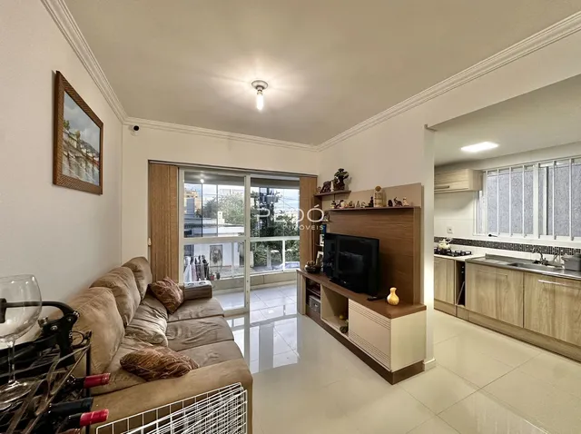 Sala de estar moderna com sofá e portas de vidro abrindo para o exterior.